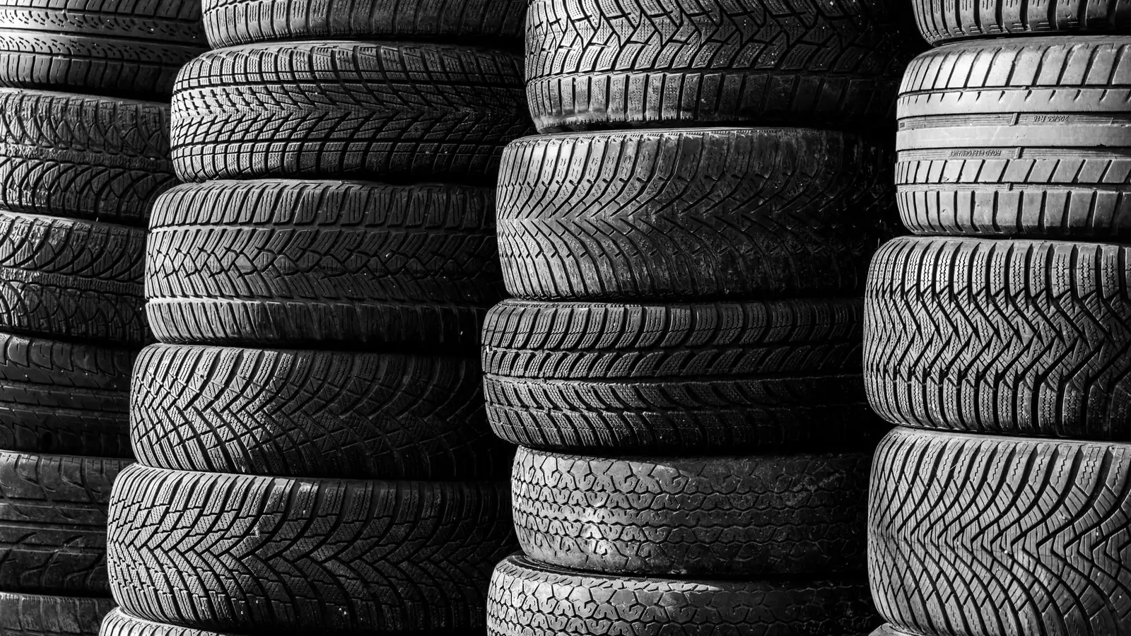 Piles de pneumatiques neufs vus de face, bandes de roulement en caoutchouc