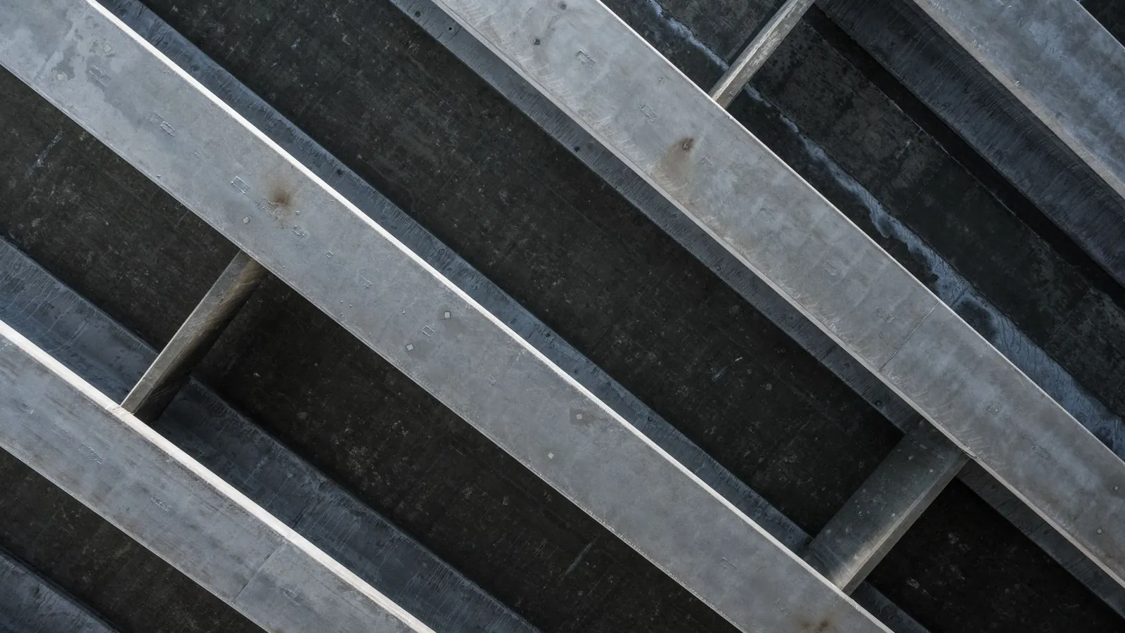 Profilés en acier galvanisé vus en contre-plongée, surface gris mat uniforme