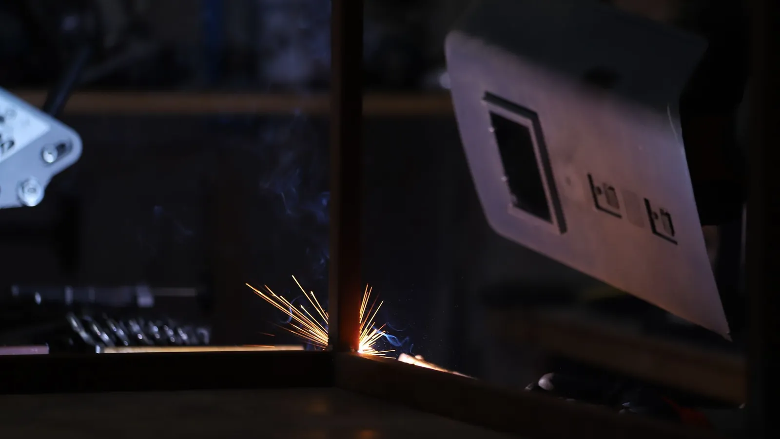 Tête de soudage laser montée sur un bras robotisé dans une cellule de production