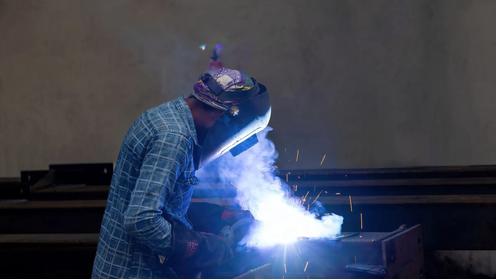 Soudage en atelier avec projections d'étincelles et fumée sous l'arc