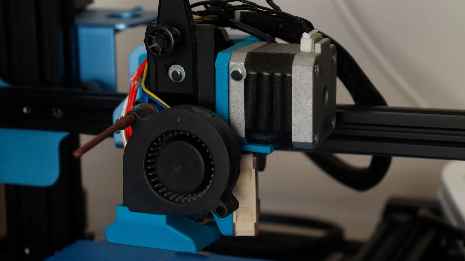 Tête d'impression d'une imprimante 3D à fil : moteur pas à pas, ventilateur de buse et supports imprimés bleus
