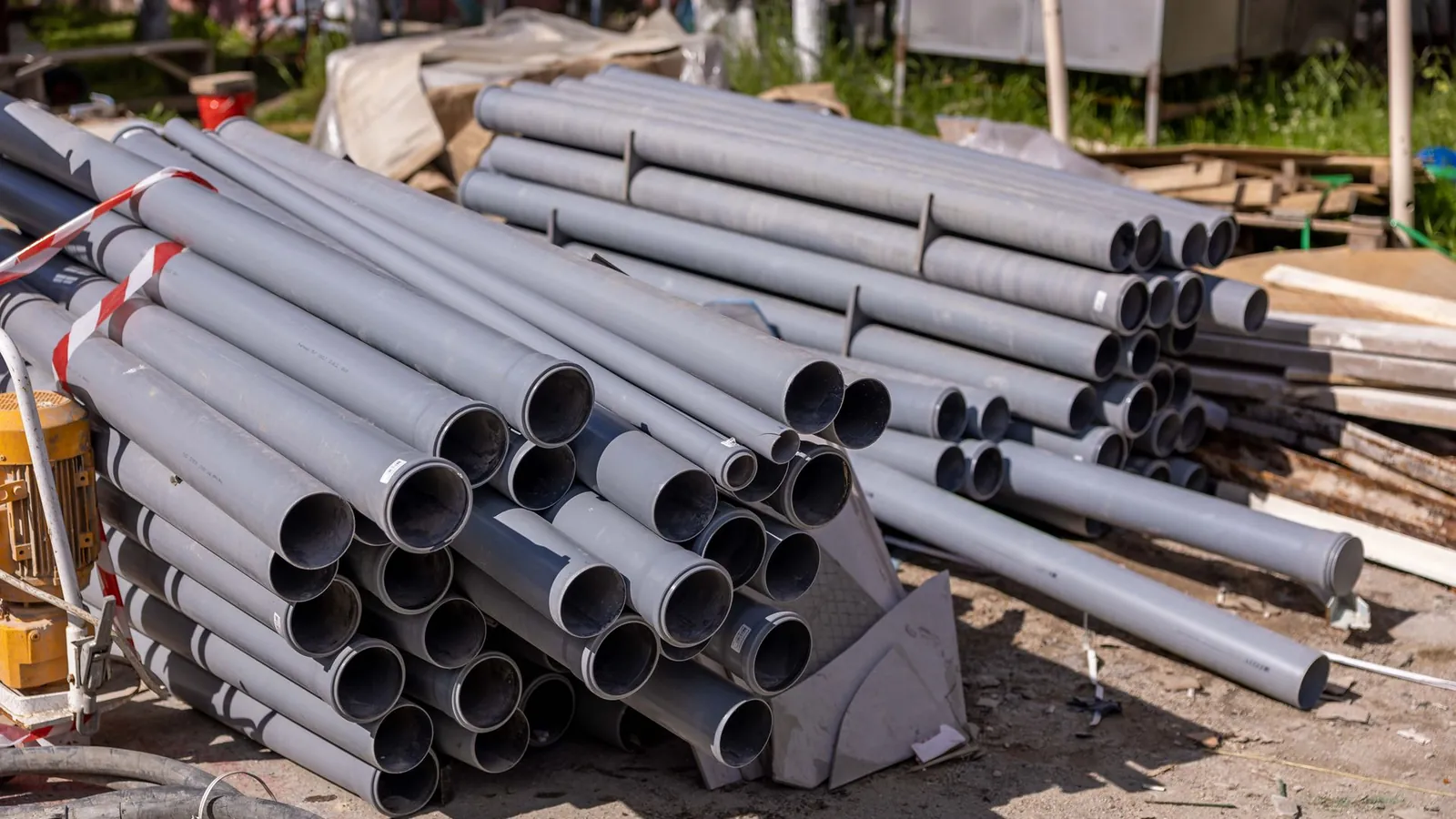 Tubes en PVC extrudé empilés en fagots sur une aire de stockage extérieure