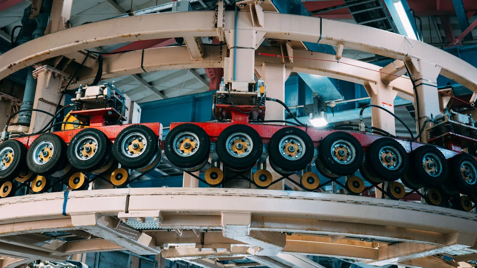 Convoyeur aérien circulaire acheminant des roues montées dans une usine automobile