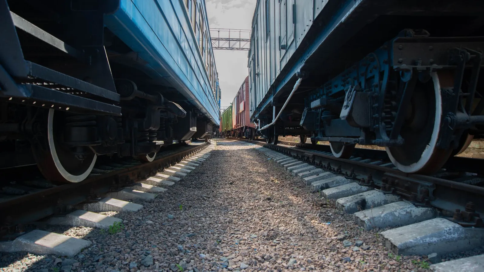 Roues et bogies de voitures voyageurs de part et d'autre d'une voie de dépôt ferroviaire