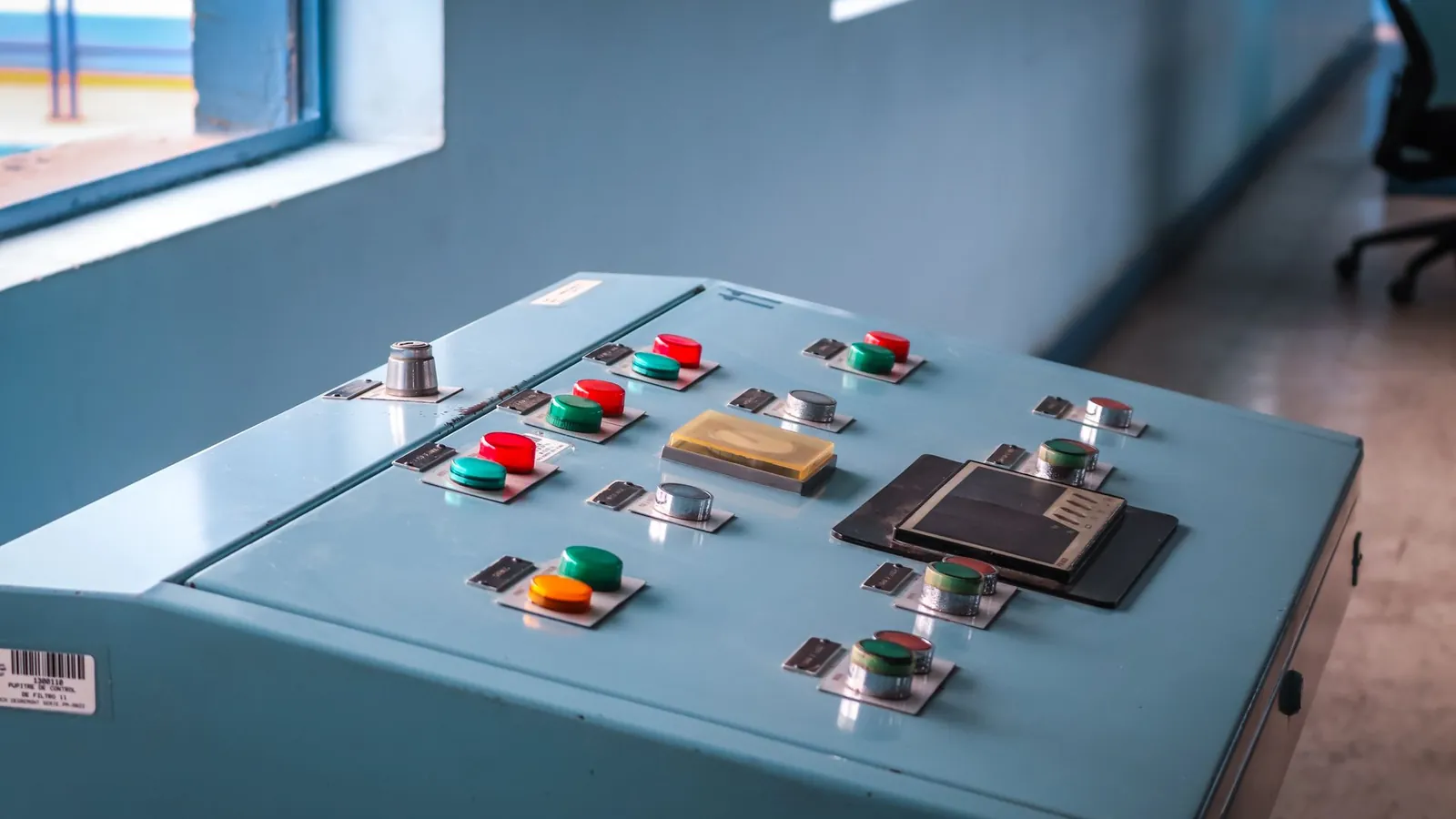 Pupitre de commande d'une installation automatisée : boutons lumineux, arrêts et voyants sur un coffret métallique