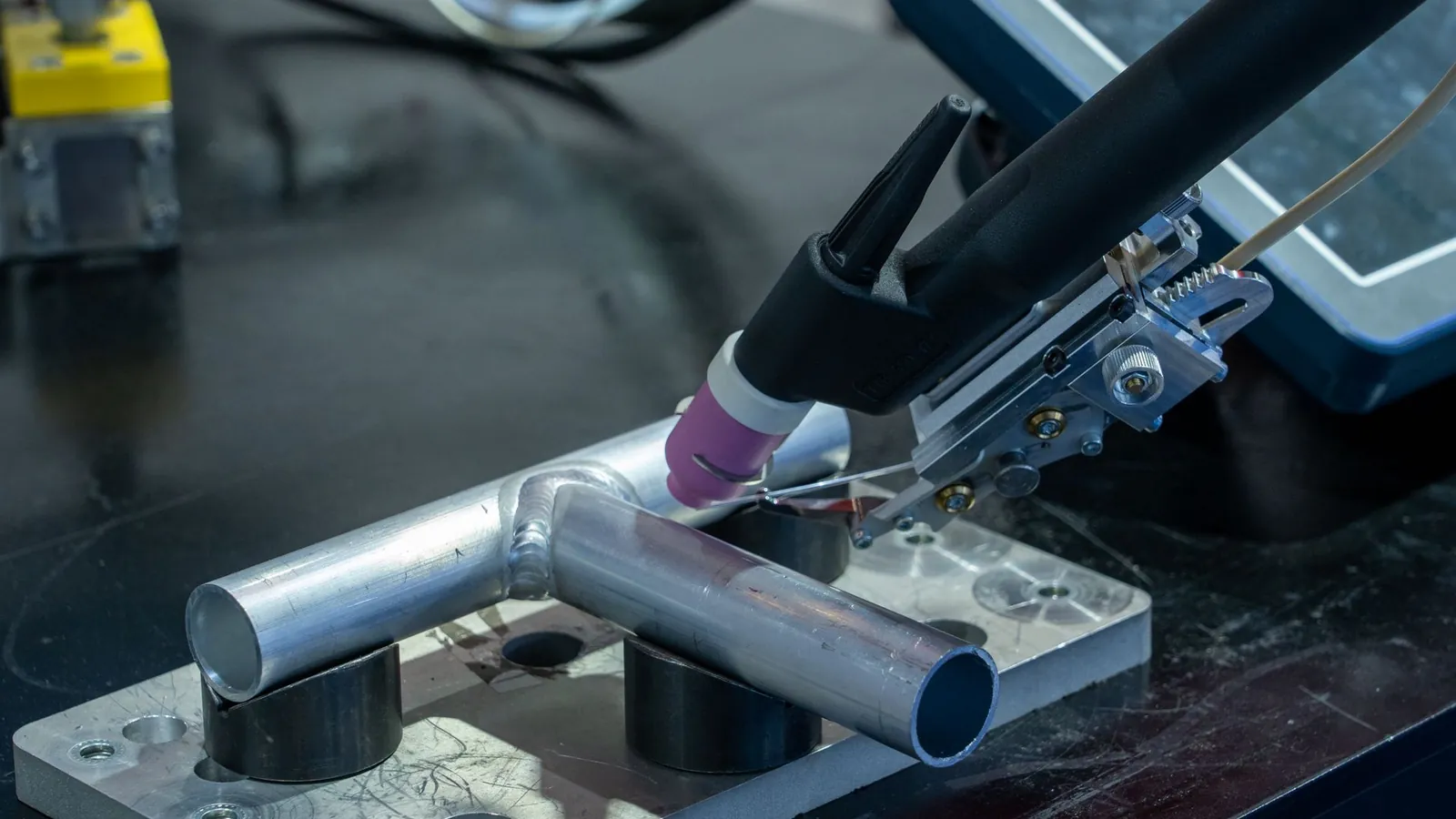 Torche de soudage TIG automatisée assemblant deux tubes d'aluminium bridés sur un gabarit