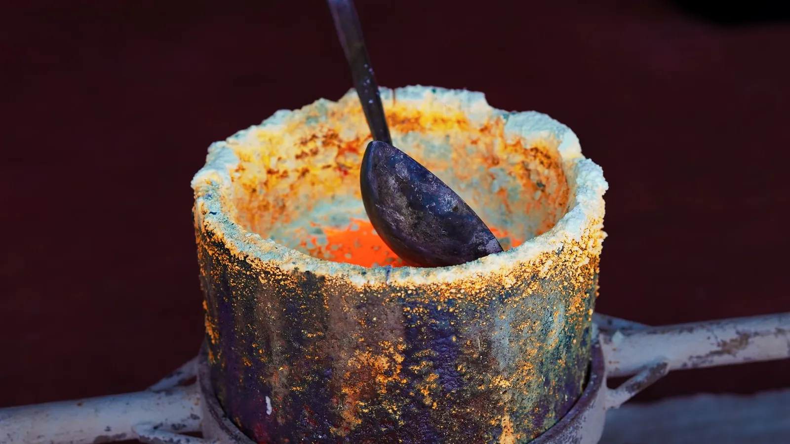 Creuset de métal en fusion et sa louche de coulée, parois couvertes de scories oxydées