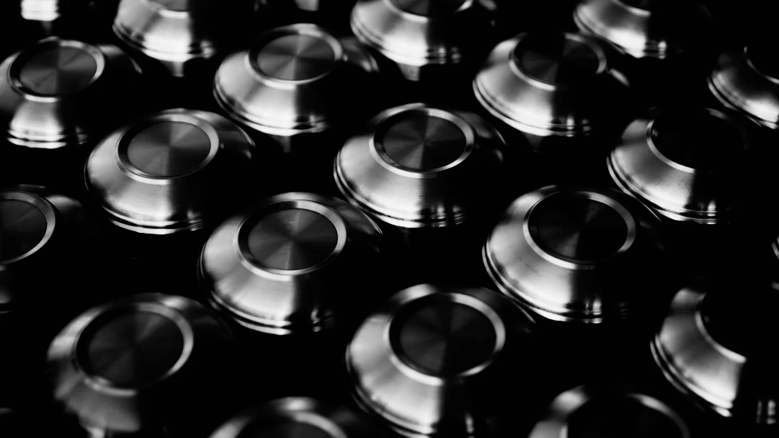 Bols en métal poli retournés, photographiés en noir et blanc, fonds aux stries concentriques bien visibles