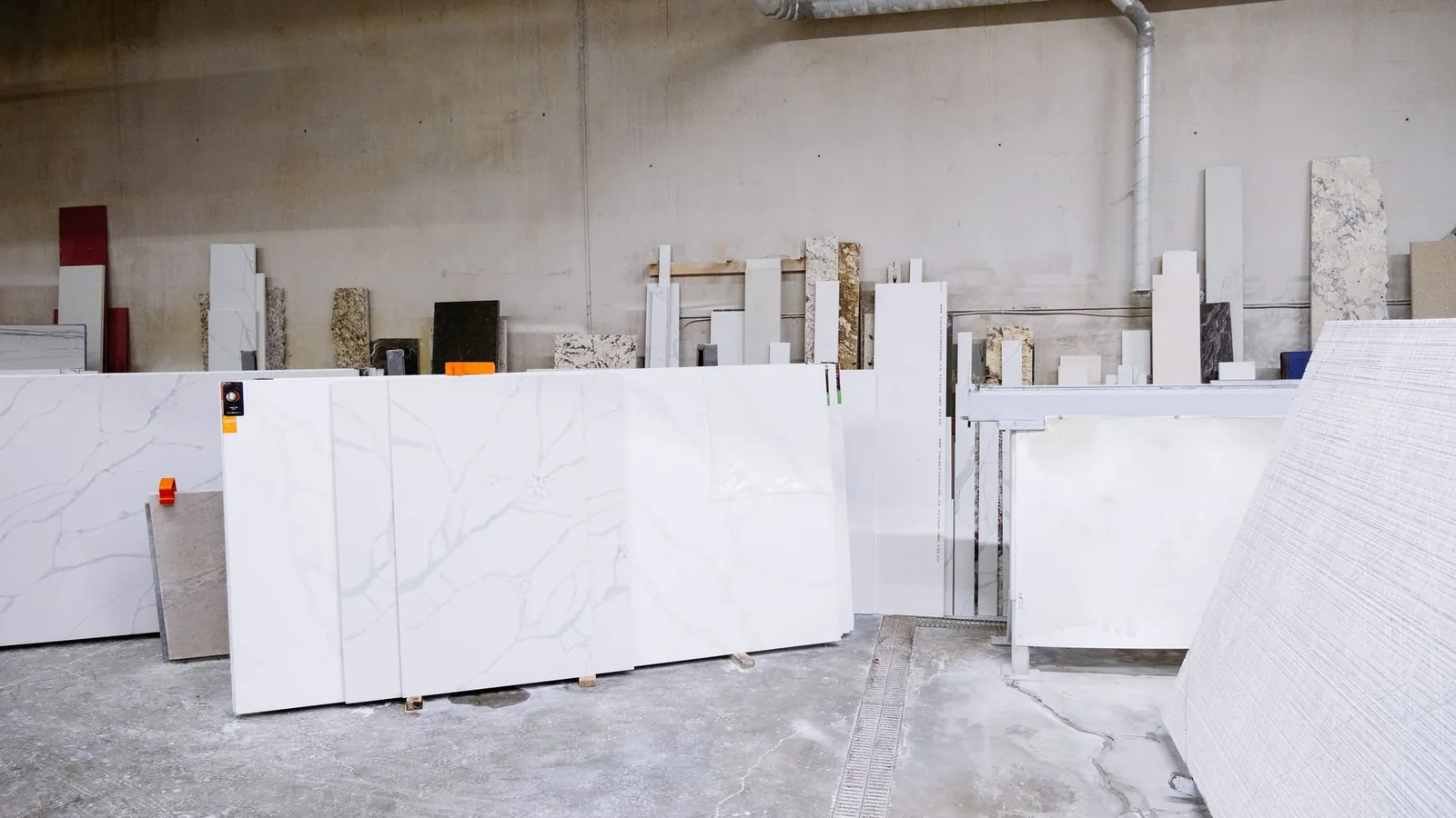 Tranches de pierre et de quartz dressées contre le mur d'un atelier de découpe