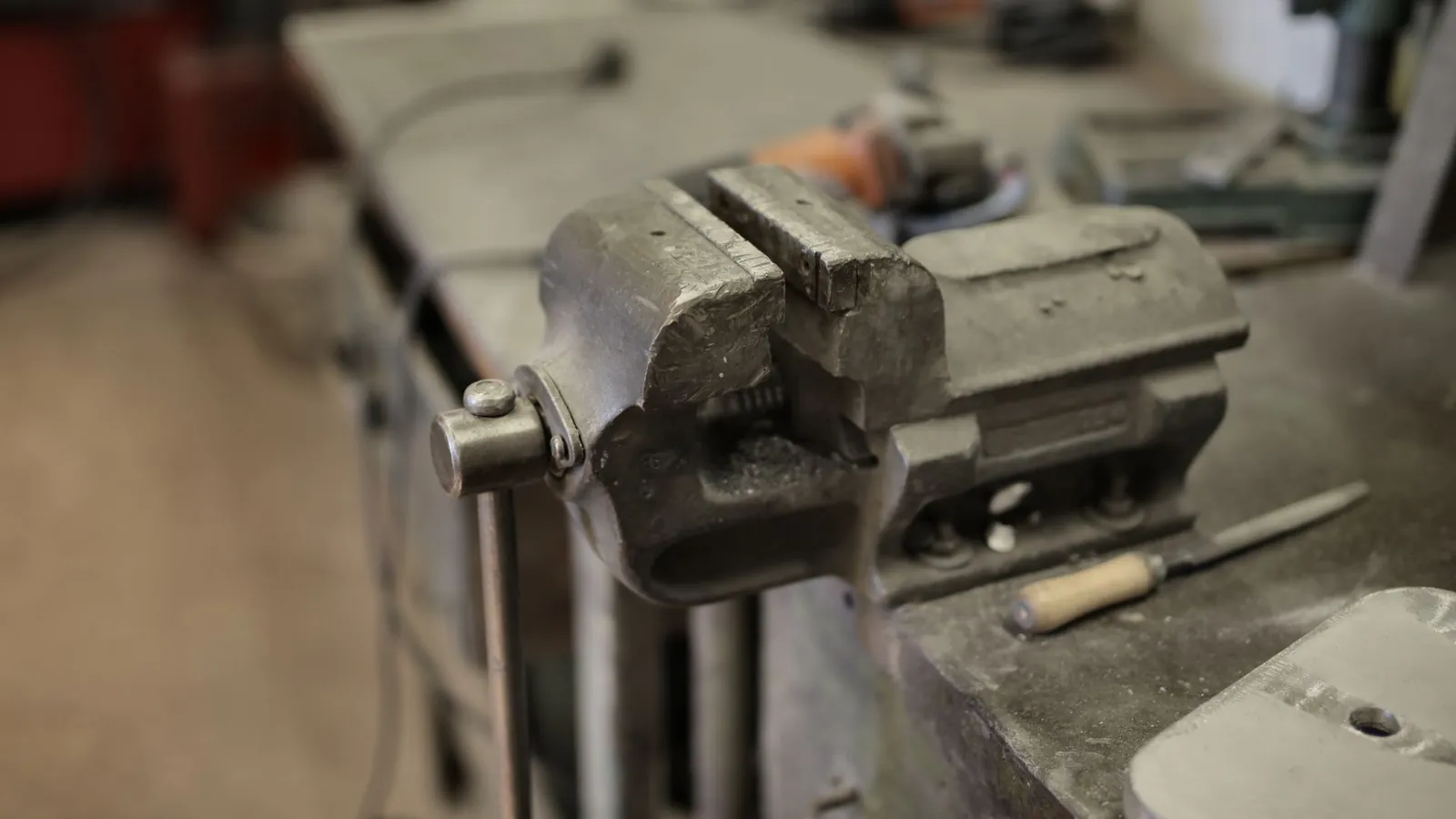 Étau d'établi en fonte fixé sur un établi d'atelier, lime posée à côté