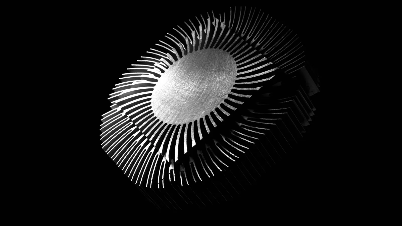 Dissipateur thermique métallique à ailettes rayonnantes, en noir et blanc sur fond noir