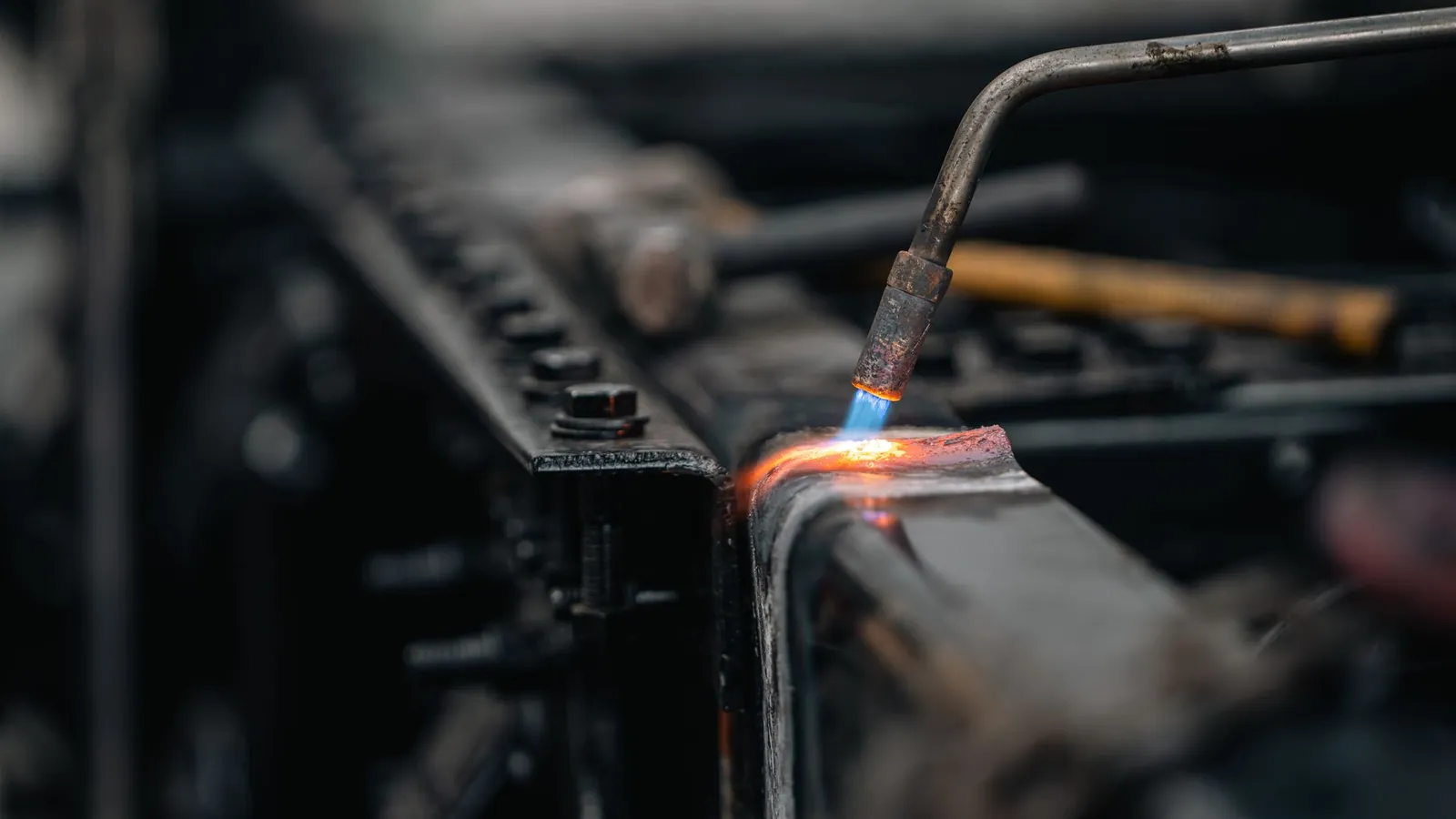 Chalumeau à flamme bleue chauffant au rouge le bord d'une pièce en acier