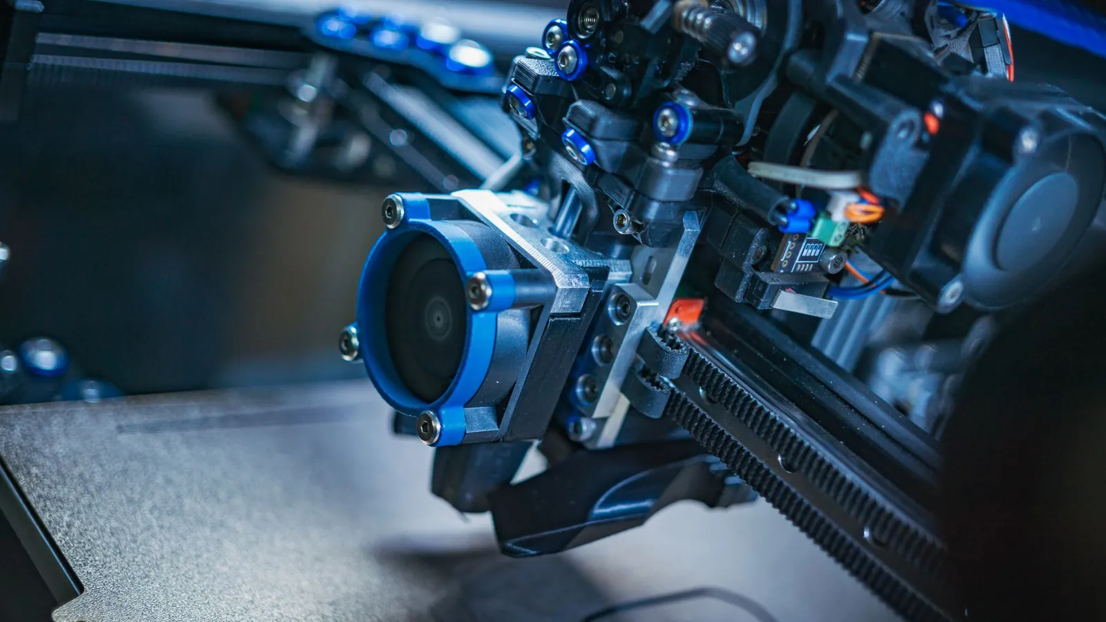 Tête d'impression d'une imprimante 3D à dépôt de fil, ventilateur et guidages en gros plan au-dessus du plateau