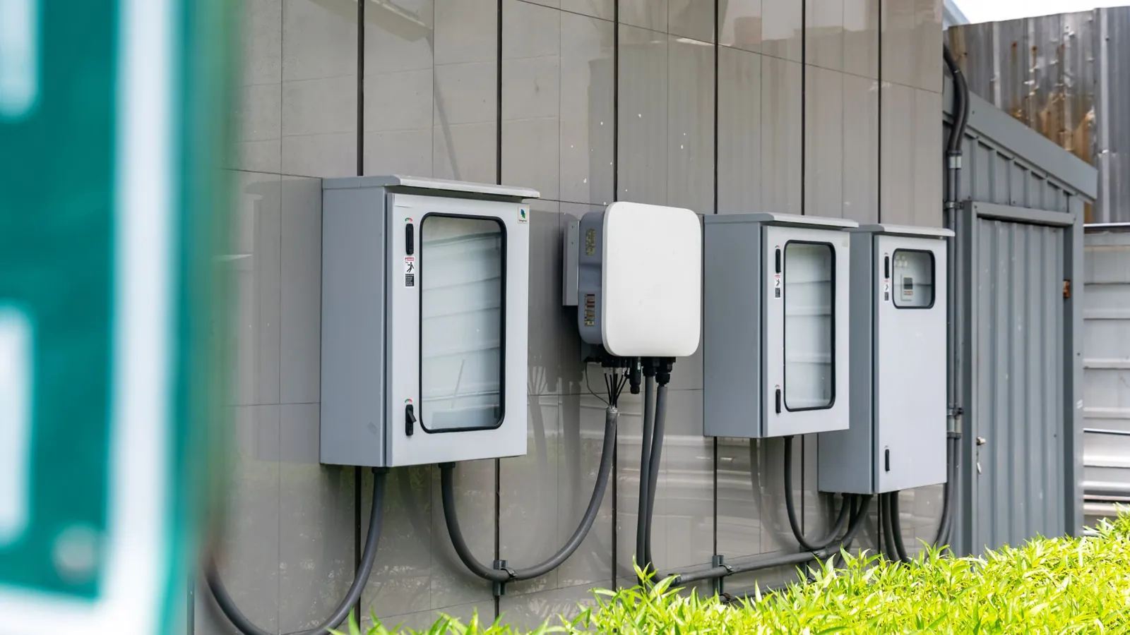 Coffrets électriques en tôle d'acier peinte à portes vitrées fixés sur une façade
