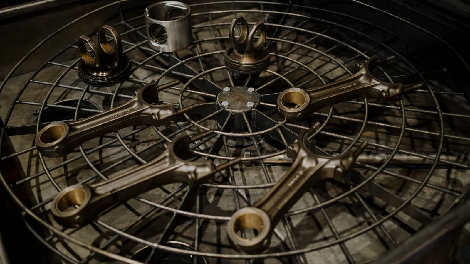 Bielles et pistons usinés disposés sur une grille de lavage