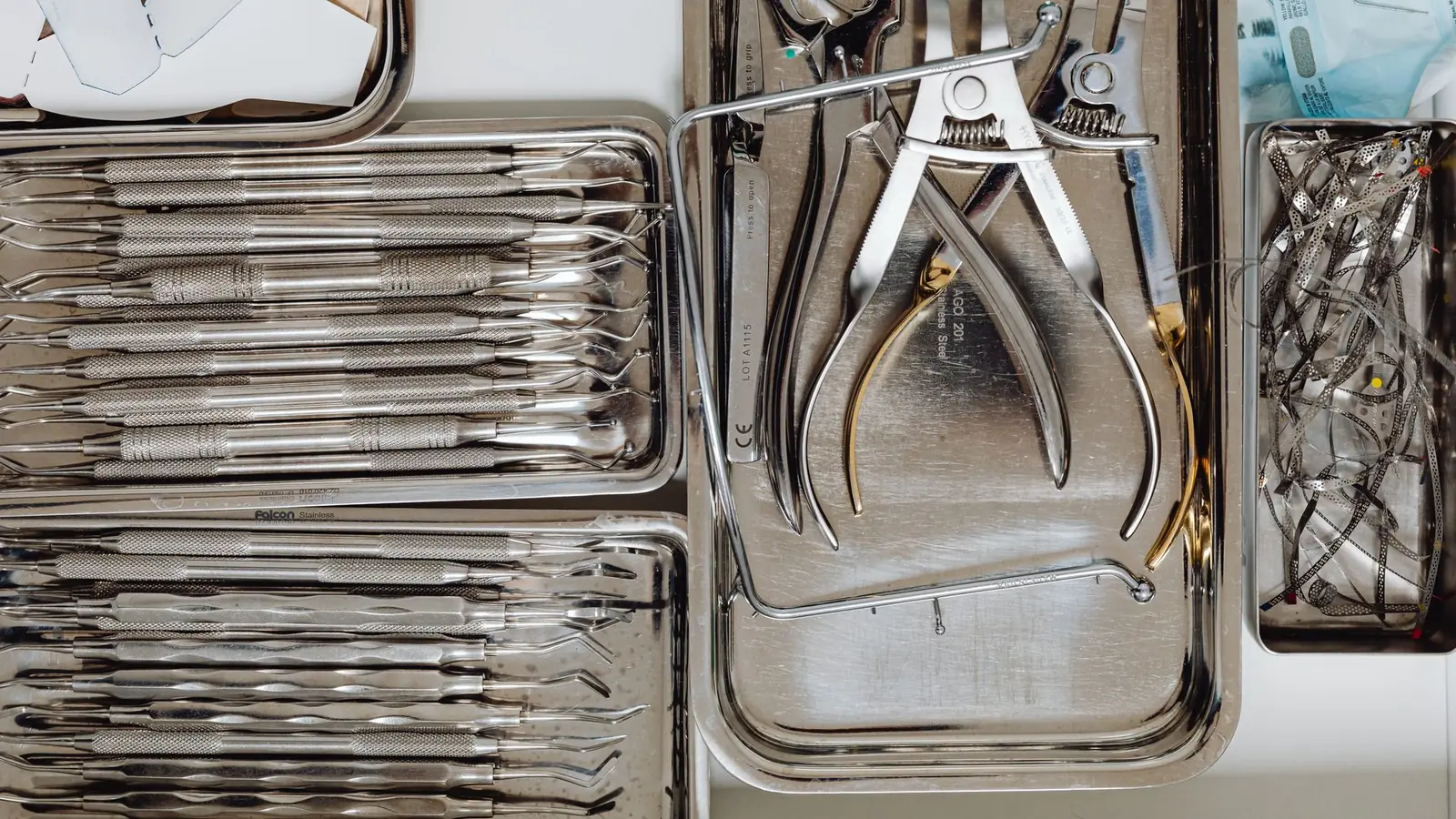 Instruments dentaires en inox rangés dans des plateaux en acier inoxydable